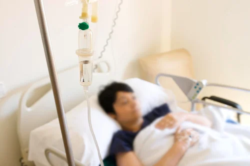 женщина лежит под капельницей для печени